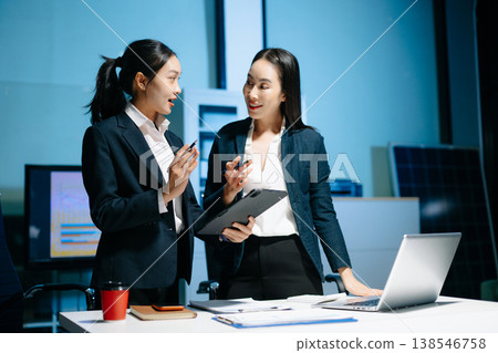 Two professional businesswomen reviewing data on tablet during office meeting. Teamwork, planning, collaboration, technology 138546758