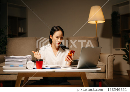 Asian woman using calculator for financial accounting and tax return at night home office. Asian woman using calculator for financial accounting and tax return at night home office. 138546831