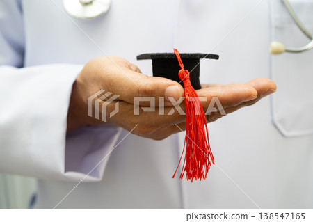 Asian woman doctor holding graduation hat in hospital, Medical education. 138547165