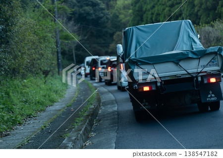 清晨尖峰時段,山路上交通擁擠——一長串汽車排成一列。 清晨尖峰時段,山路上交通擁擠——一長串汽車排成一列。 138547182