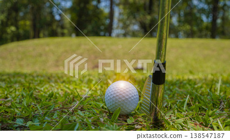 Golf clubs and golf balls on a green lawn in a beautiful golf course with morning sunshine. Golf clubs and golf balls on a green lawn in a beautiful golf course with morning sunshine. 138547187