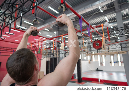 An athletic man practices at a ninja club's indoor obstacle course. An athletic man practices at a ninja club's indoor obstacle course. 138548476