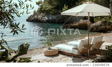lifestyle photography, beach lounge with white linen and wicker furniture on the shore of a mediterranean cove where there is an umbrella to shading from the sun 138549574