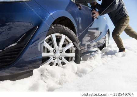 Pushing a car stuck in the snow 138549764