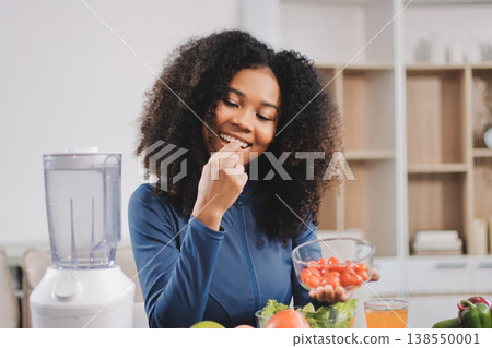 Young nutritionist showing bell peppers during an online video call consulting about healthy eating, sitting at home at a table with vegetables, laptop and measuring tape Young nutritionist showing bell peppers during an online video call consulting about healthy eating, sitting at home at a table with vegetables, laptop and measuring tape 138550001