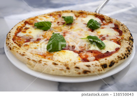 Delicious Hot Margherita Pizza on White Plate with Marble Background Delicious Hot Margherita Pizza on White Plate with Marble Background 138550043
