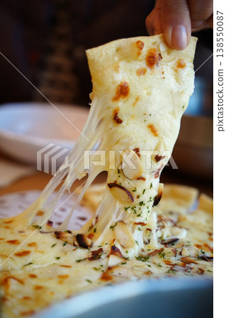 lose-up of Cheesy Pizza Slice Being Pulled with Long Cheese Strings lose-up of Cheesy Pizza Slice Being Pulled with Long Cheese Strings 138550087