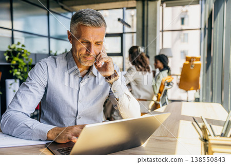 Focused agent examining documents while engaging with clients 138550843