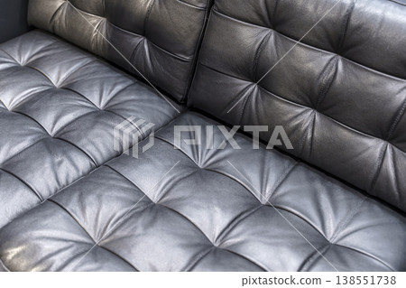 Black Quilted Leather Sofa Corner Close Up with Soft Cushioned Texture Details 138551738