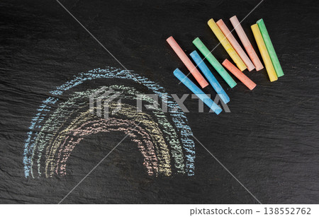 Colorful chalks pile on black background, different colors crayons on dark stone plate Colorful chalks pile on black background, different colors crayons on dark stone plate 138552762