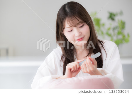 女性在家中進行指甲護理；一張展現女性用指甲銼修整指甲的美麗生活照。 138553034