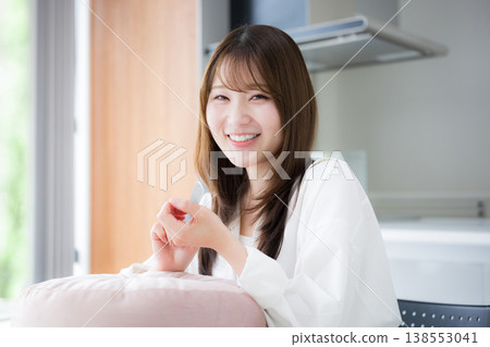 女性在家中進行指甲護理;一張展現女性用指甲銼修整指甲的美麗生活照。 女性在家中進行指甲護理;一張展現女性用指甲銼修整指甲的美麗生活照。 138553041