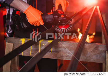 A man cleans metal using an angle grinder. Many sparks 138553228