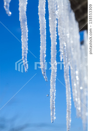 Long natural icicles on a sky background Long natural icicles on a sky background 138553309