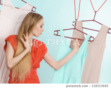 Woman choosing clothes in shop Woman choosing clothes in shop 138553695