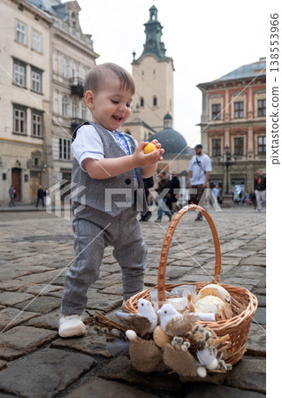 Toddler with easter basket in historic city square 138553966