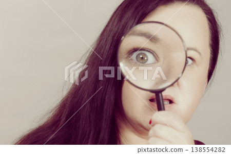 Adult woman with magnifying glass Adult woman with magnifying glass 138554282