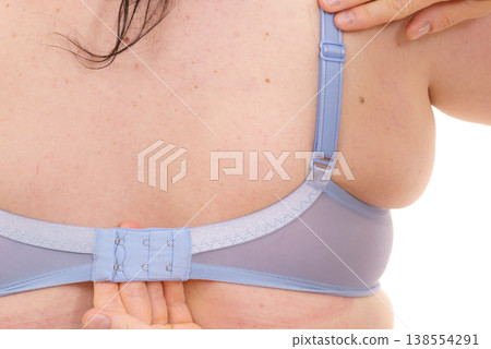 Bra fitter help plus size woman find perfect fit. Back view. Bra fitter help plus size woman find perfect fit. Back view. 138554291