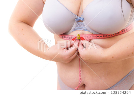 Woman plus size measuring her chest under breast Woman plus size measuring her chest under breast 138554294