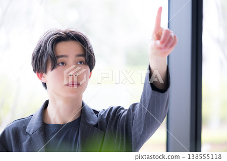 An image of a young businessman's decision and strategy, pointing a finger forward and tapping it several times, indicating the direction of the future. 138555118