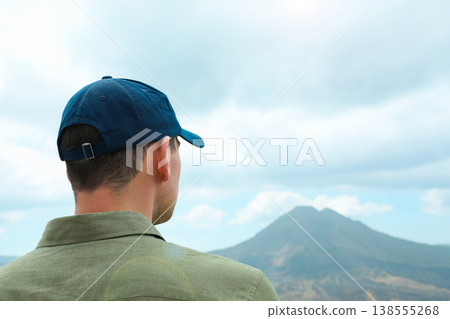 A man stands and looks at Mount Batur in Kintamani Bali A man stands and looks at Mount Batur in Kintamani Bali 138555268