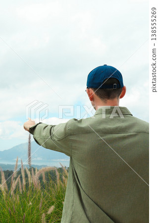 A person stands in Kintamani Bali pointing towards the landscape A person stands in Kintamani Bali pointing towards the landscape 138555269