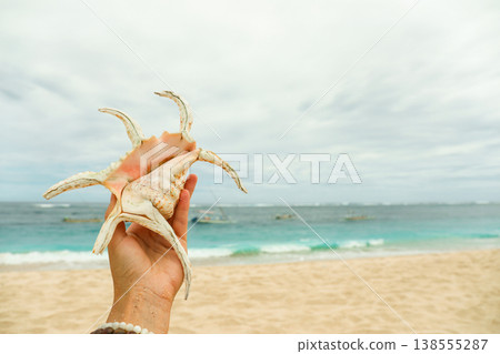 Holding a shell at a Bali beach during vacation time 138555287