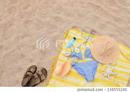 Beach towel with summer items like a bikini, hat, and sunscreen 138555292