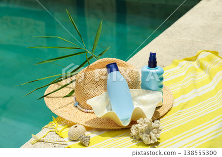Sunscreen and hat are placed by a poolside in Bali Sunscreen and hat are placed by a poolside in Bali 138555300
