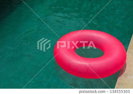 A pink float rests next to a clear pool in Bali 138555303