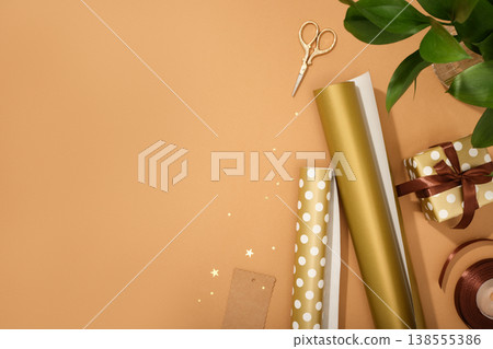 Gift wrapping materials. Rolls of wrapping paper, ribbon, gift. Brown background, space for your text. Preparing for the holidays Gift wrapping materials. Rolls of wrapping paper, ribbon, gift. Brown background, space for your text. Preparing for the holidays 138555386