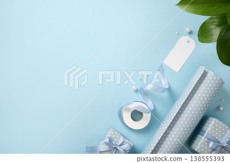 Wrapping background with rolls of paper, ribbon and blank tag on blue background. Copyspace. Wrapping background with rolls of paper, ribbon and blank tag on blue background. Copyspace. 138555393