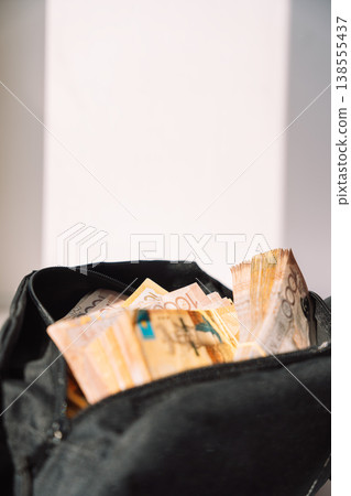 Cash in Kazakhstani tenge banknotes inside a black bag near window, savings and finance concept Cash in Kazakhstani tenge banknotes inside a black bag near window, savings and finance concept 138555437