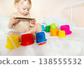 child in hospital lying in bed with mobile phone smiling 138555532