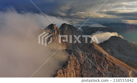 Amazing rocky mountains in clouds at sunset Amazing rocky mountains in clouds at sunset 138555842