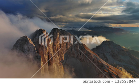 Amazing rocky mountains in clouds at sunset Amazing rocky mountains in clouds at sunset 138555844