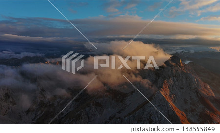 Amazing rocky mountains in clouds at sunset Amazing rocky mountains in clouds at sunset 138555849