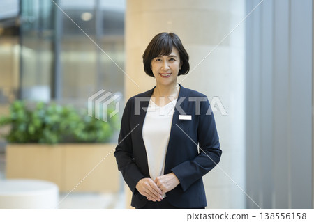 一位六十多歲的女商人面帶微笑地直視鏡頭，這是她的肖像照。 138556158