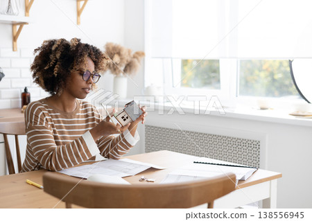female architect or realtor holds mock up of house in her hands, deals with planning. female architect or realtor holds mock up of house in her hands, deals with planning. 138556945