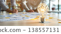 Photo of light bulb with network inside on a table with charts and people brainstorming, concept of innovation and teamwork 138557131