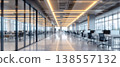 Photo of blurred modern office interior with desks and computers, workspace with glass walls and bright lighting, business environment 138557132