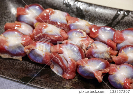 Fresh chicken gizzards arranged on a black plate Fresh chicken gizzards arranged on a black plate 138557207
