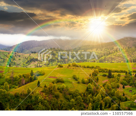 rural mountain landscape during spring at sunset. wonderful countryside scenery on a cold weather in evening light. cloudy sky above rolling hills in may. timeless nostalgia book cover with rainbow rural mountain landscape during spring at sunset. wonderful countryside scenery on a cold weather in evening light. cloudy sky above rolling hills in may. timeless nostalgia book cover with rainbow 138557566