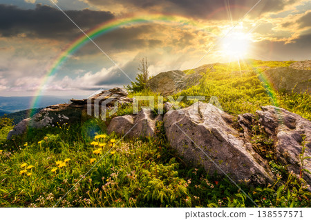sunset over carpathian mountain summer landscape. alpine meadow with huge stones among the grass on top of the hillside near the peak of mountain range. stunning sky view. weather with rainbow sunset over carpathian mountain summer landscape. alpine meadow with huge stones among the grass on top of the hillside near the peak of mountain range. stunning sky view. weather with rainbow 138557571