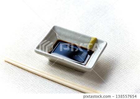 Soy sauce poured into a small white dish, with wasabi placed on the rim. Soy sauce poured into a small white dish, with wasabi placed on the rim. 138557654