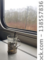 Glass Tea Cup in Metal Holder on Train Table by Window 138557836