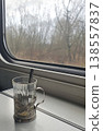 Glass Tea Cup in Metal Holder on Train Table by Window 138557837