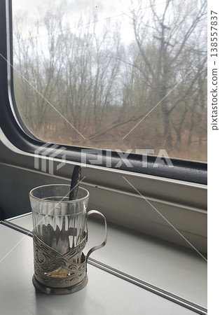 Glass Tea Cup in Metal Holder on Train Table by Window Glass Tea Cup in Metal Holder on Train Table by Window 138557837