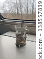 Glass Tea Cup in Metal Holder on Train Table by Window 138557839