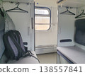 Interior of a modern passenger car with a backpack on the seat and a window. Cozy compartment for travel, clean bedding 138557841